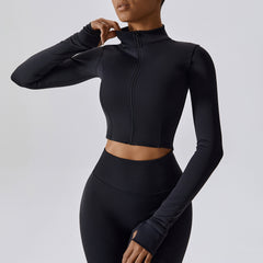 Person wearing a black long-sleeve athletic top and leggings on a light gray background